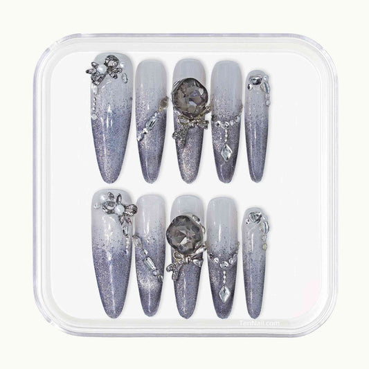 Set of decorative nails with gemstones in a clear plastic case on a white background
