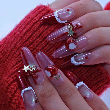 Nails with red and clear design, featuring stars and hearts, against a red textured background.by Tennail press on nails.