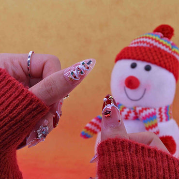Close-up of hands with decorative nail art against a colorful background with a snowman figure.