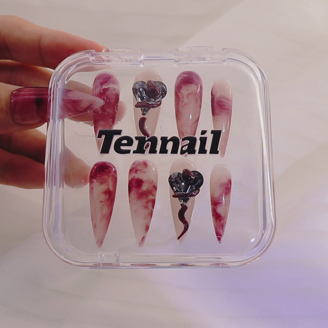 Video shows TenNail's Crimson Snake Heart Nails: Handmade press - ons with red smudges, snake elements, and heart - shaped gems catch the light as hands move, creating a unique and stylish nail appearance that stands out.