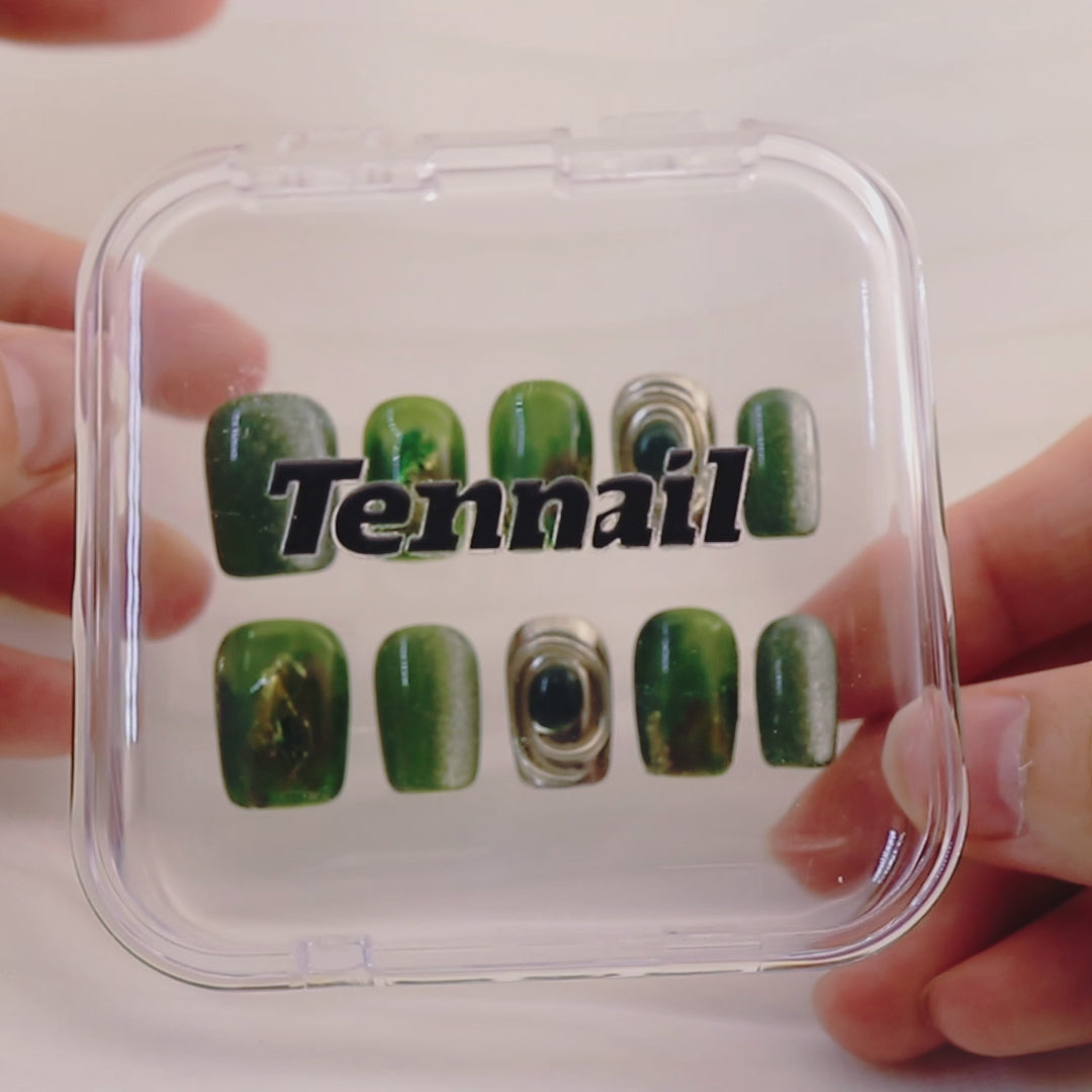 Video shows TenNail's Fairy Forest Nails: Handmade press - ons with green and silver cat - eye, swirling gem elements, and gold details catch the light as hands move, creating a magical forest - inspired appearance that's perfect for a unique nail style.