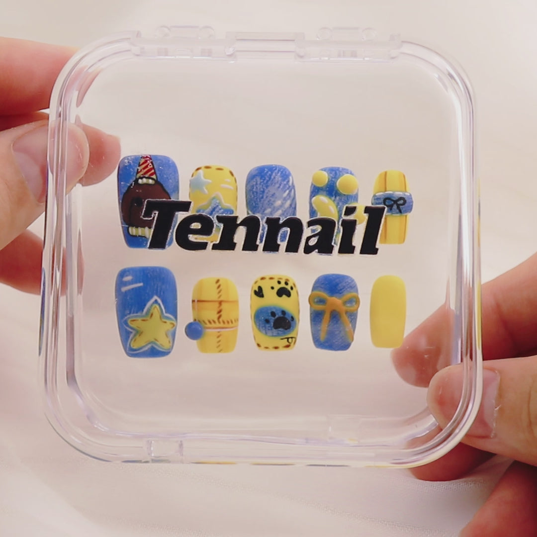 Video shows TenNail's Whimsy Pup Nails: Press - on nails with adorable puppy illustrations, star details, and a vibrant blue - yellow color combo catch the light as hands move. This creates a fun, cheerful style that exudes joy and playfulness, making them a charming addition to any outfit.