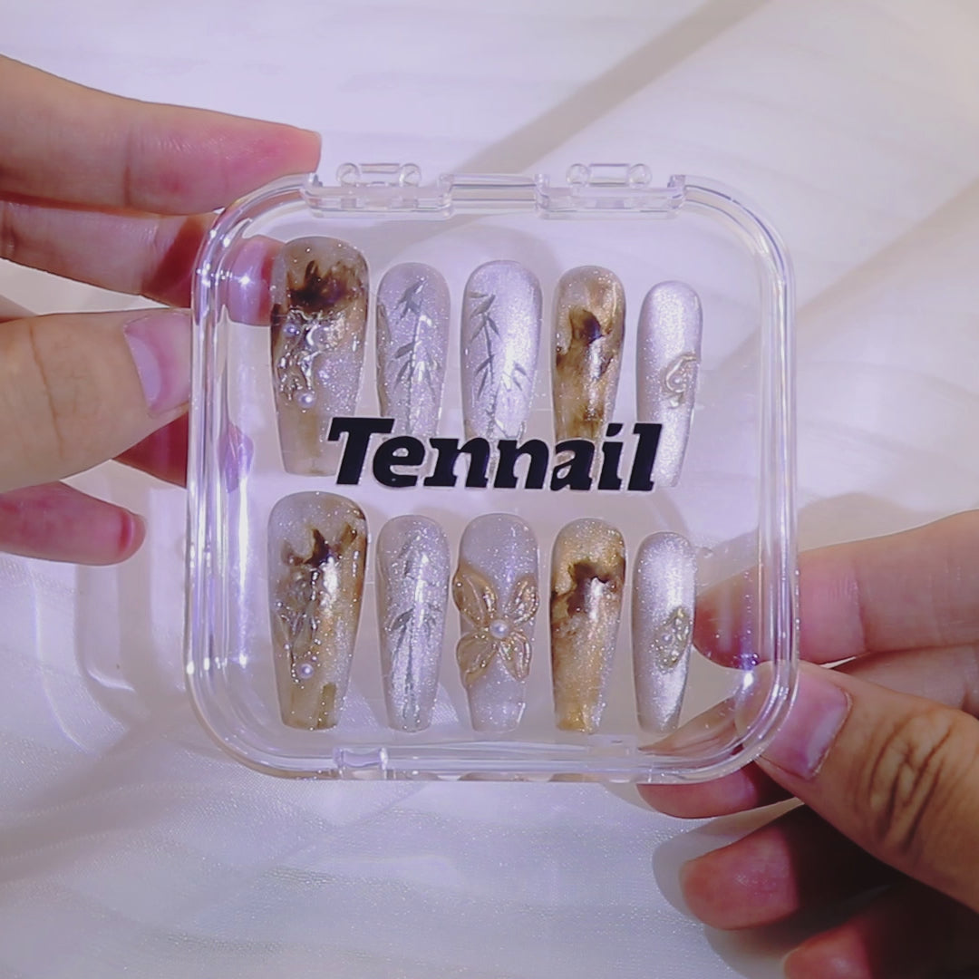 Video shows TenNail's Maillard Bamboo Nails: Press - ons with hand - painted bamboo and gold smudges catch light as hands move, crafting a refined autumn - winter inspired look.