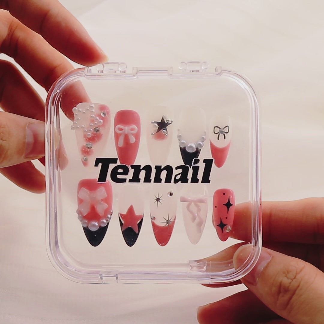 Video shows TenNail's Pearl Bow Nails: Press - on almond - shaped nails with pearls, rhinestones, and bows catch the light as hands move, creating a cute, sparkling look that accentuates the beauty of deep skin tones.