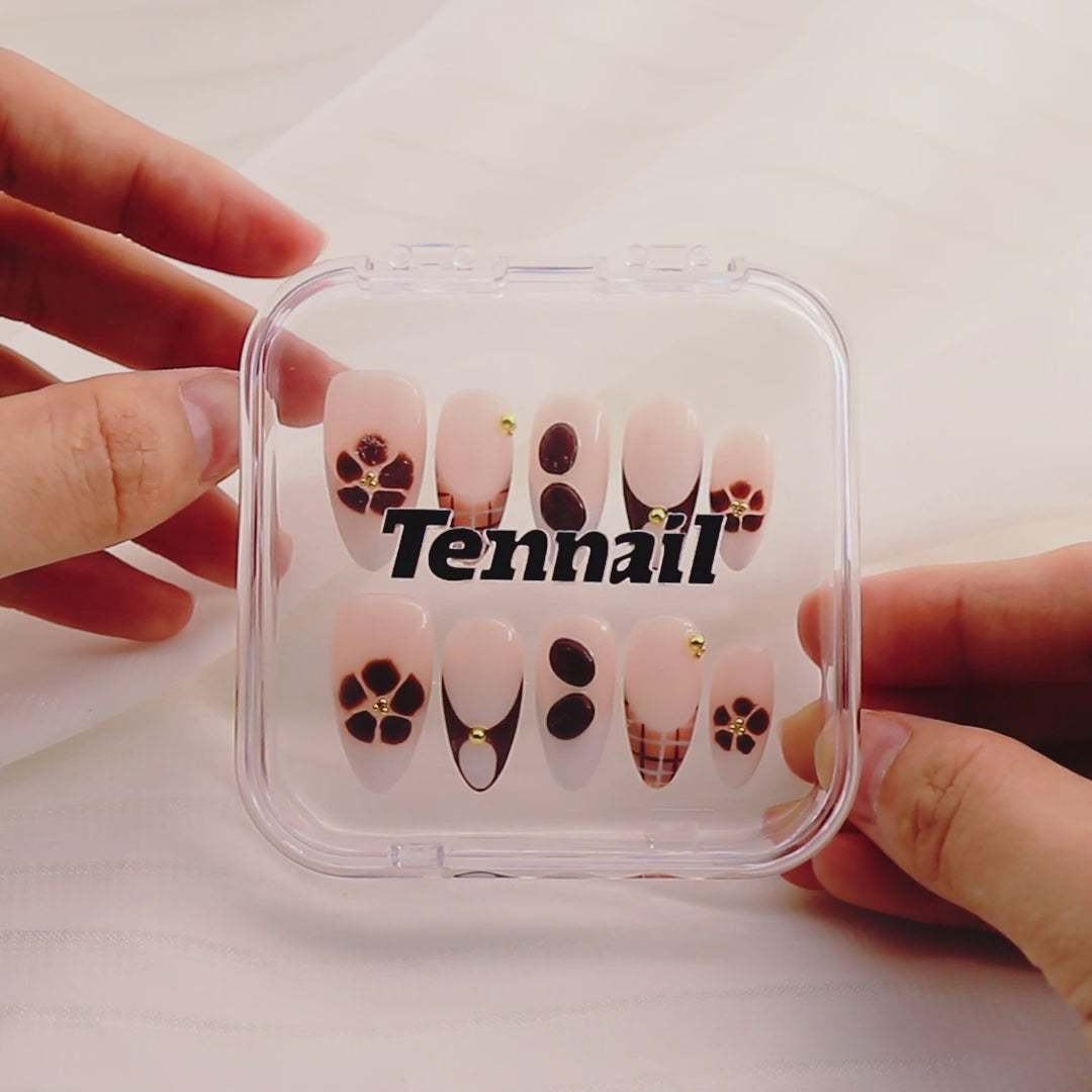 Video shows TenNail's Coco Bead Nails: Press - on nails with brown French tips and gold bead decorations glisten as hands move, creating a stylish and elegant appearance that catches the eye.