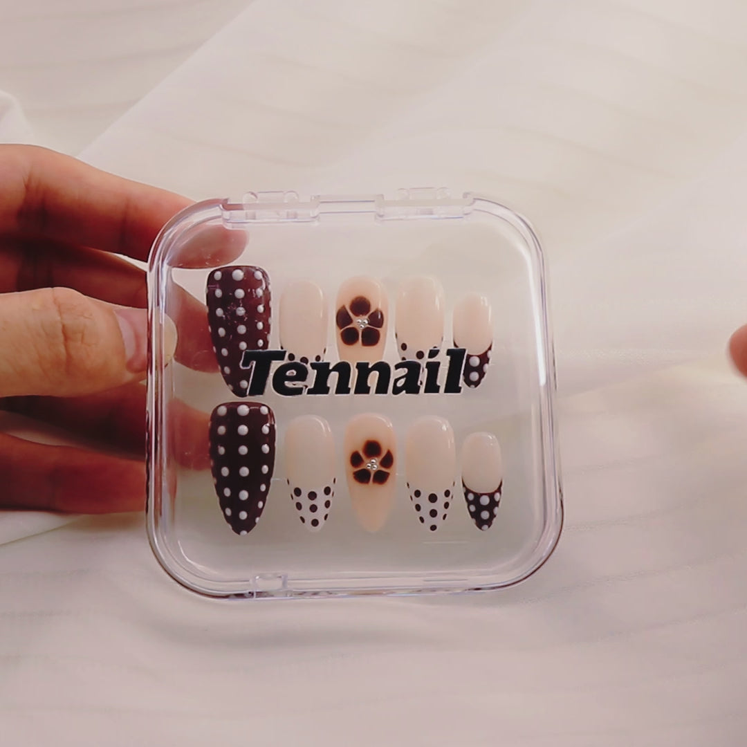 Video shows TenNail's Mocha Dots Nails: Press - on nails with brown and white polka dots and brown floral accents catch the light as hands move, creating a subtly luxurious and stylish appearance that exudes charm.