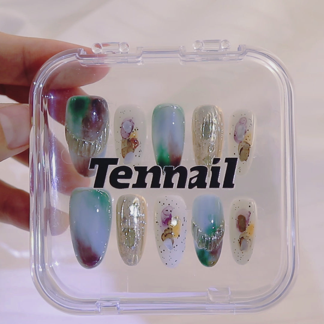 Video shows TenNail's Mythic Melt Nails: Press - on nails with blended gradient colors and gem - inspired accents catch the light as hands move, creating a mythical and artistic nail look that's sure to impress with its creative allure.