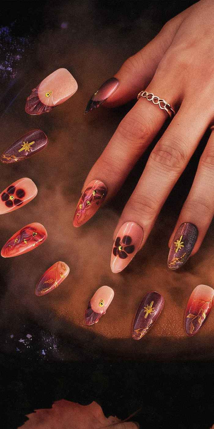 Hand with floral nail art on a dark surface