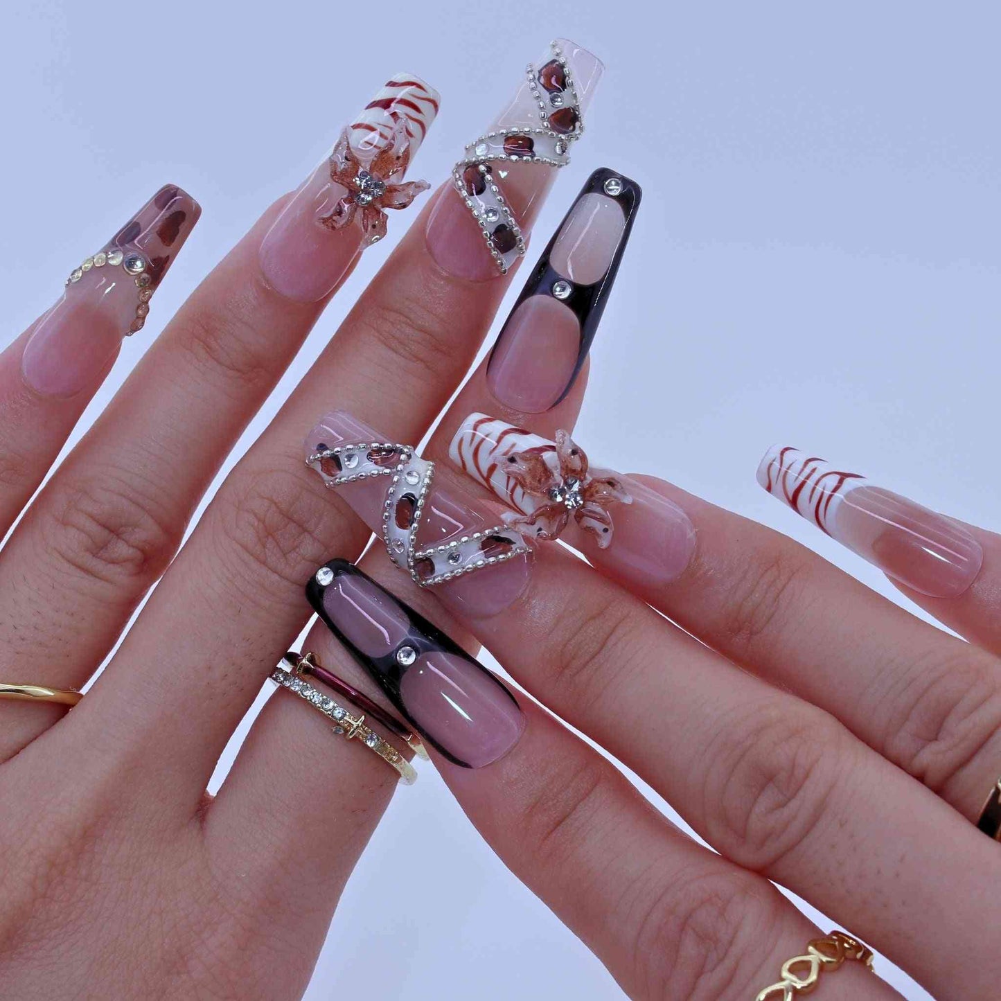Close-up of hands with decorative nail art on a light background by Tennail press on nails.