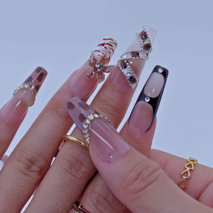 Close-up of a hand with decorative nails on a light background by Tennail press on nails.