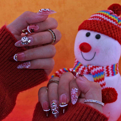 Close-up of hands with decorative nails against an orange background with a snowman. by Tennail press on nails.