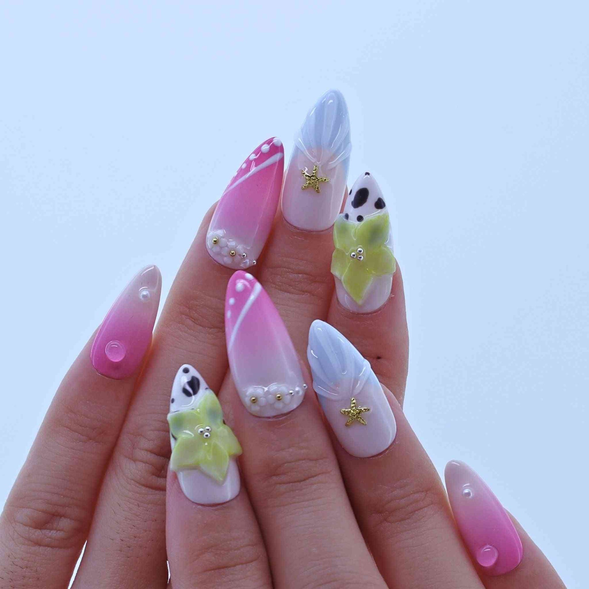 Nails with colorful designs on a light blue background by Tennail