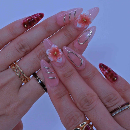 Close-up of a hand with decorative nails and rings on a blurred background by Tennail.