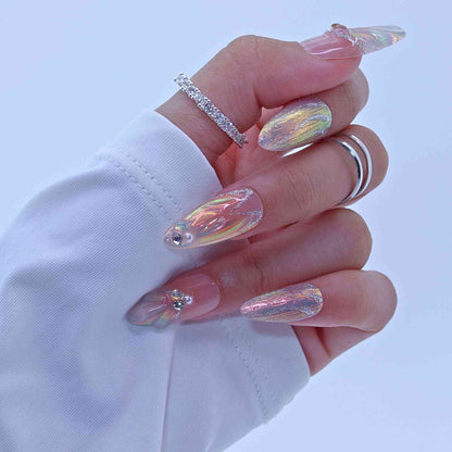 Hand with iridescent nail art and rings on a light blue background by Tennail.