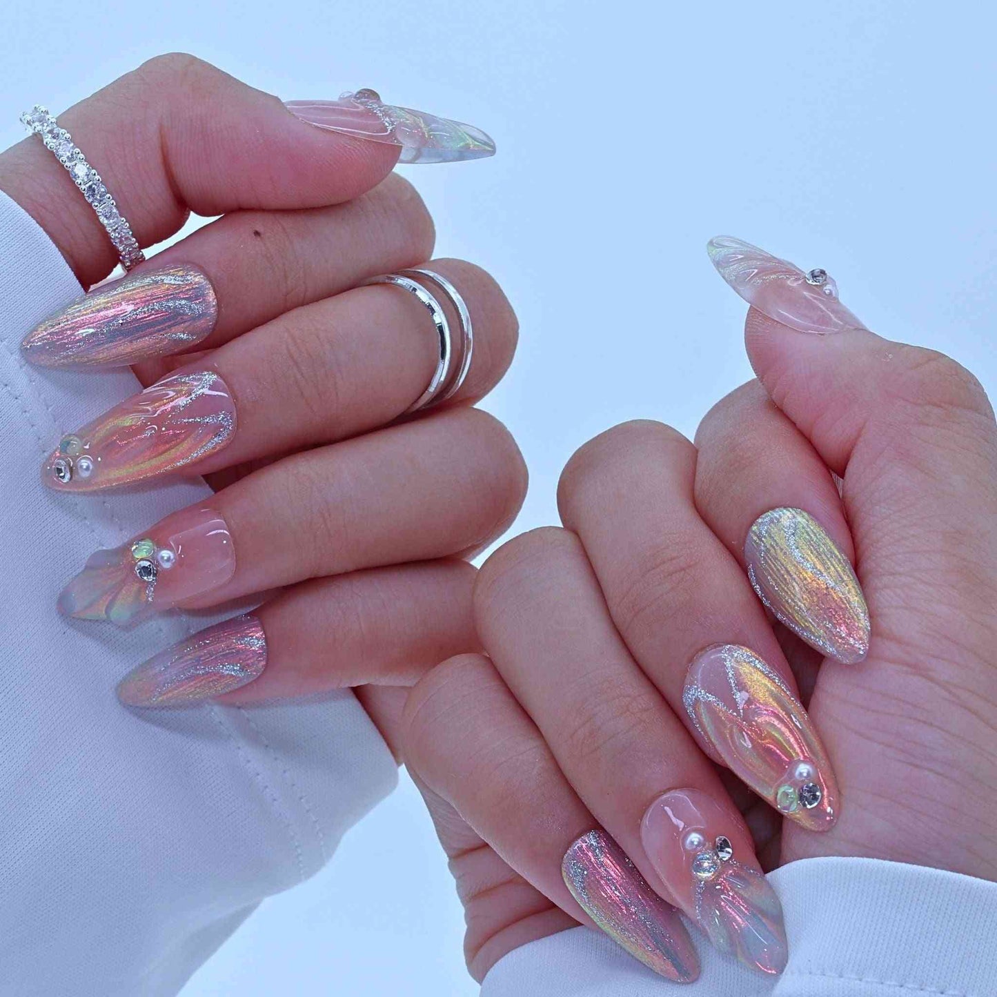 Close-up of hands with iridescent nail art by Tennail.