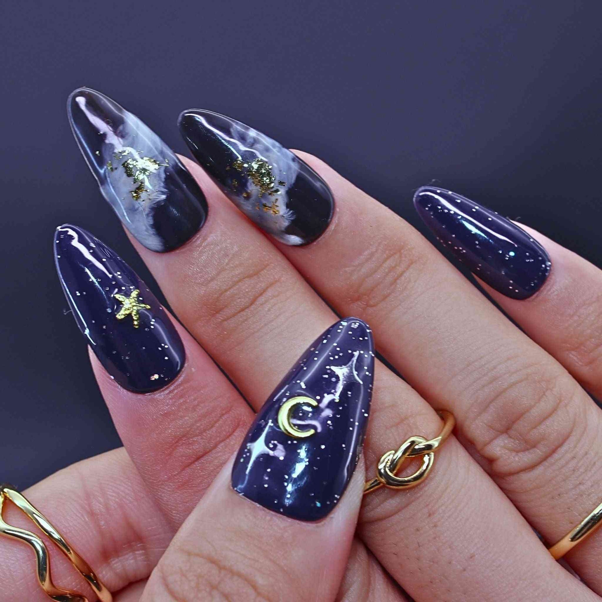 Navy blue nail polish with celestial designs by Tennail.