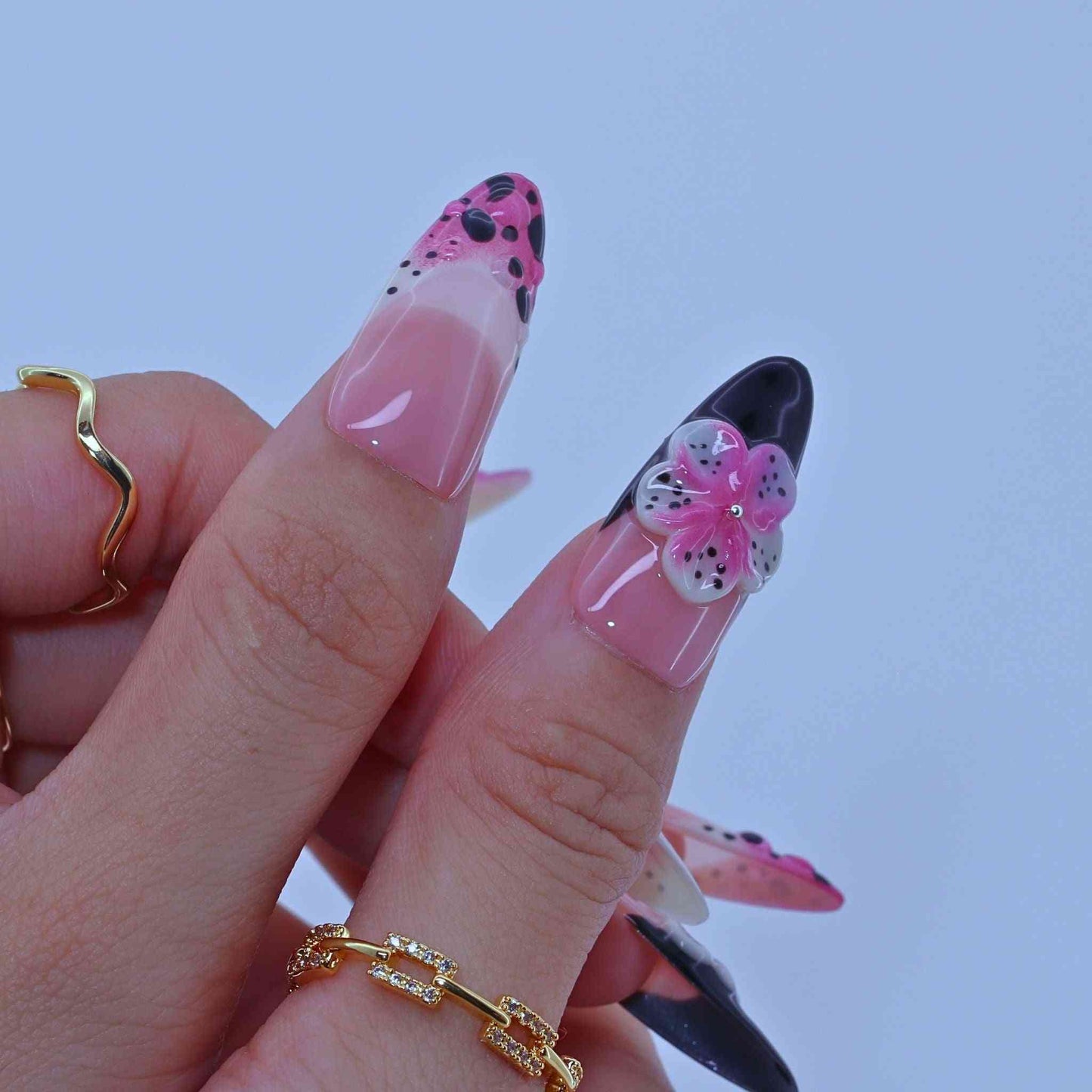 Nail art with pink and black designDotted Blossom Nails with black dots, purple florals, hand-painted art by Tennail