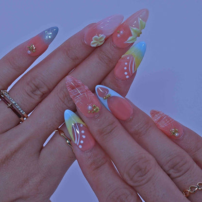 Close-up of a hand with colorful nail art , Coastal Bloom press on Nails with hand-painted florals, starfish accents, coastal hues by Tennial