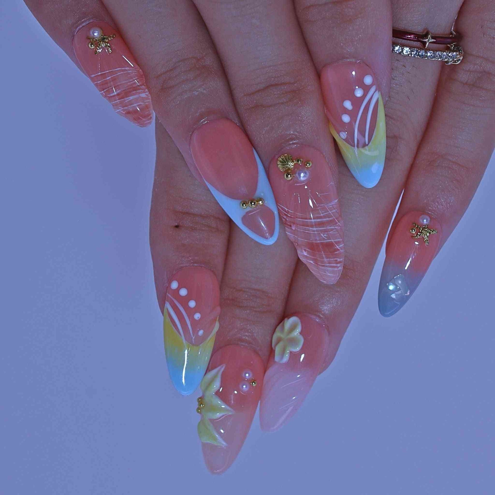 Close-up of hands with colorful nail art  , Coastal Bloom press on Nails with hand-painted florals, starfish accents, coastal hues by Tennial