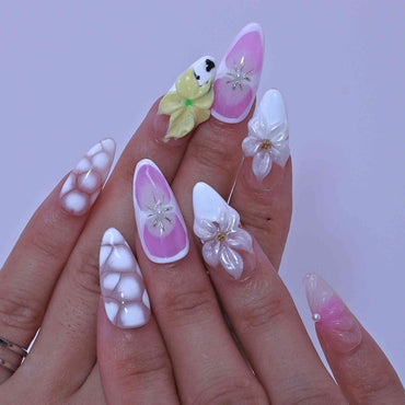 Hand with decorative nails featuring flowers and a bird, Pastel Floral press on Nails with hand-painted florals, pastel hues, delicate accents by Tennail