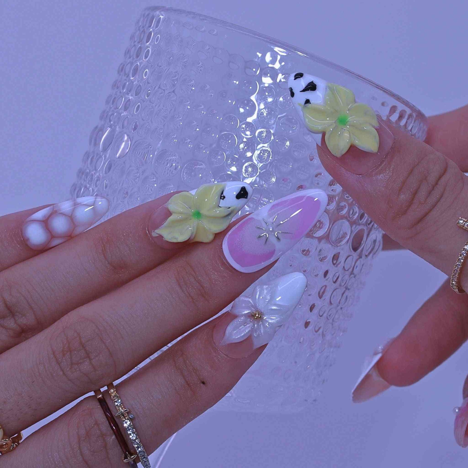 Close-up of a hand with floral nail art Pastel Floral press on Nails with hand-painted florals, pastel hues, delicate accents by Tennail