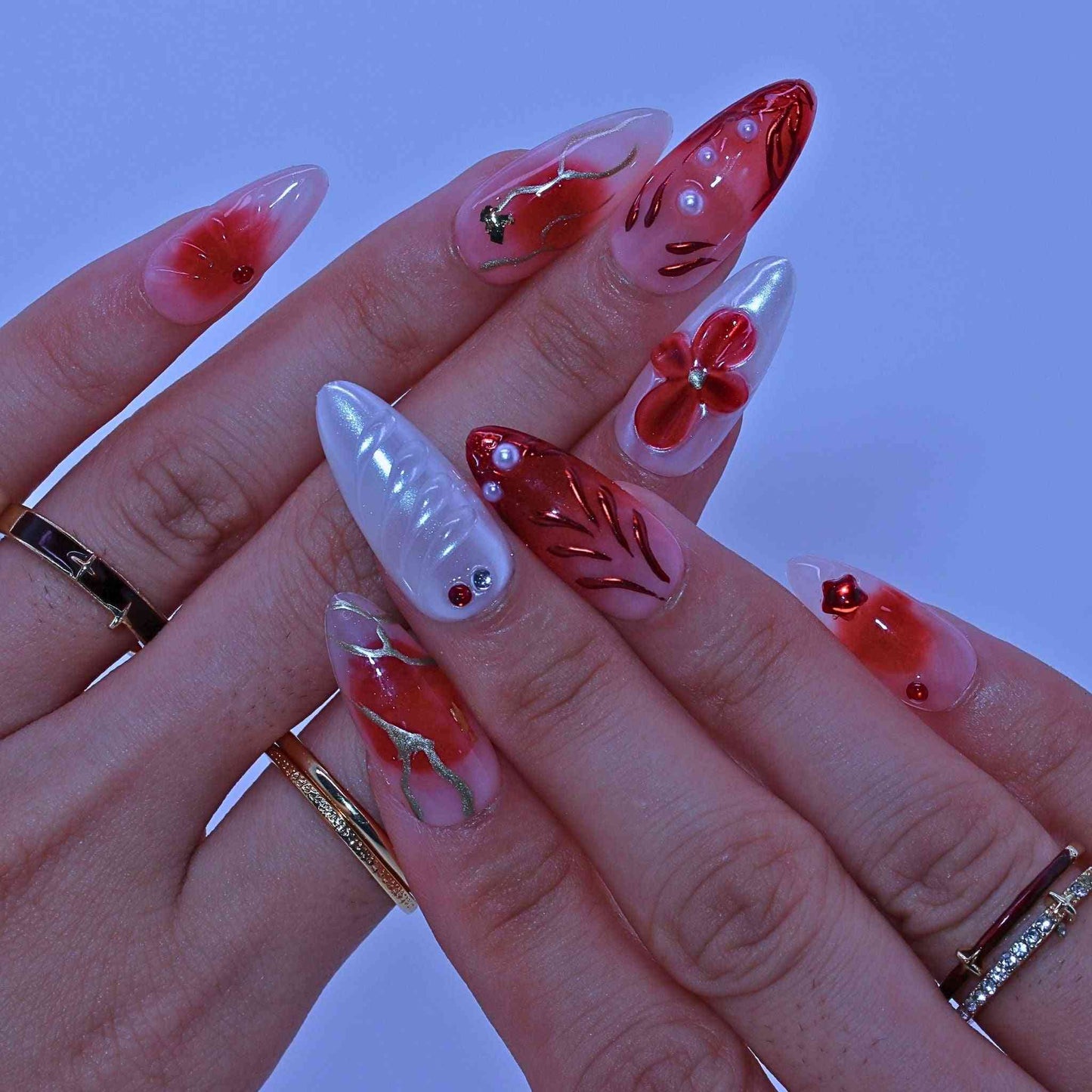 Hand with red and white floral nail art , Crimson Bloom press on Nails with hand-painted red florals, gradients, rhinestone accents by Tennail