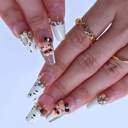 Close-up of hands with decorative nail art featuring small animal figures and gemstone, Kitty Leopard press on Nails with leopard print, Kitty accents, bling by Tennail.
