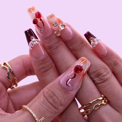 T2511N059 Cherry Blossom Glow Nails byTenNail, Close-up of hands with decorative nail art on a pink background