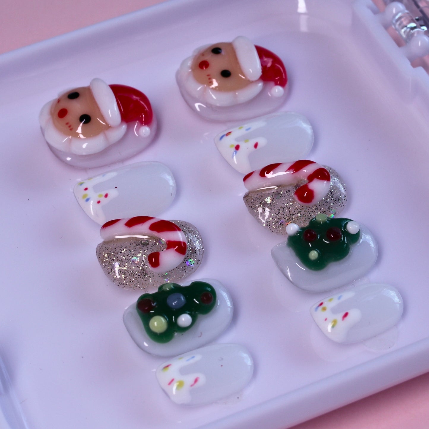 Short Christmas press on nails with Santa and candy cane designs.