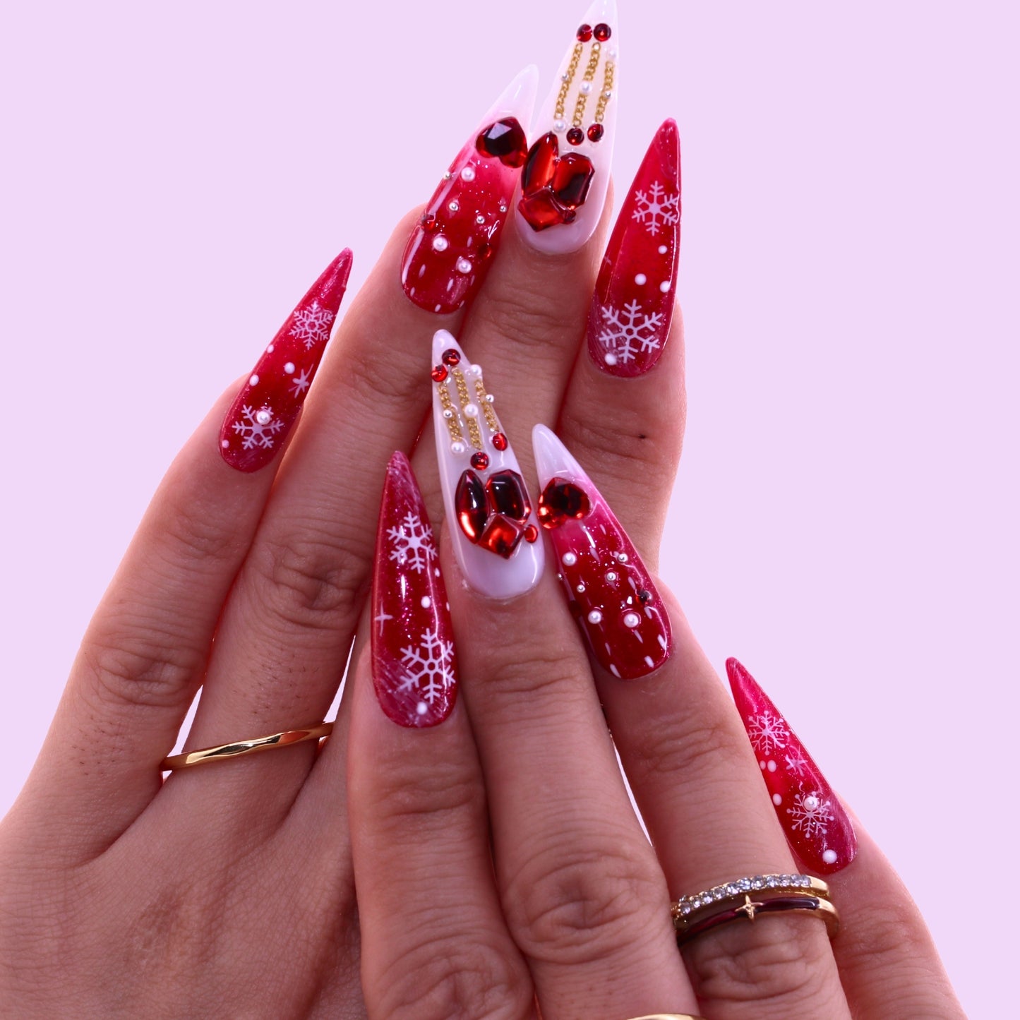 Hand with red and white Christmas-themed nail art, Tennail handmade press on nails.