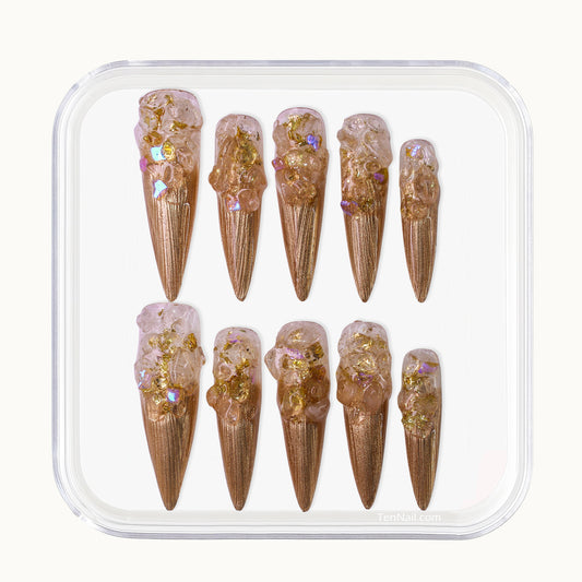 Long Stiletto press-on nails in metallic gold with a clear 3D crushed crystal texture.