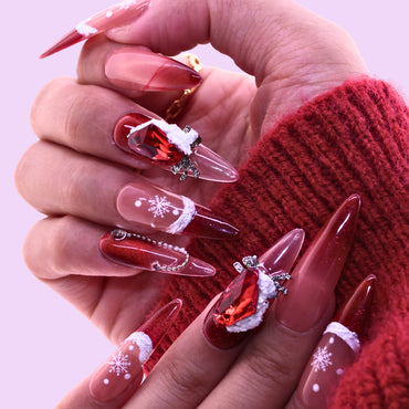 Hand with festive nail art featuring red and clear designs, Tennail handmade press on nails.