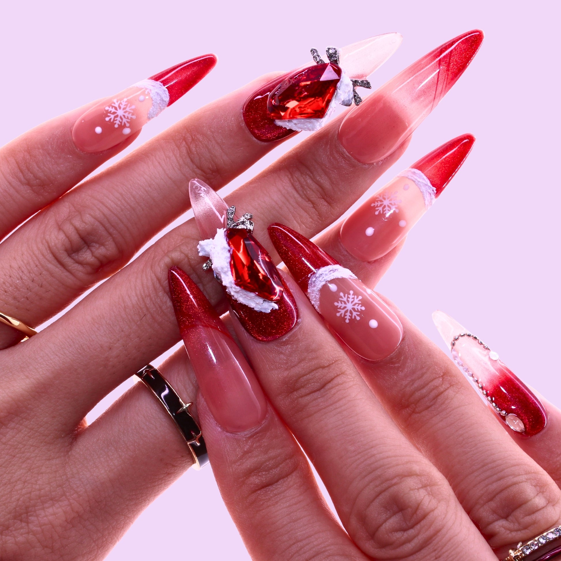 Close-up of hands with red and clear Christmas-themed nail art, Tennail handmade press on nails.