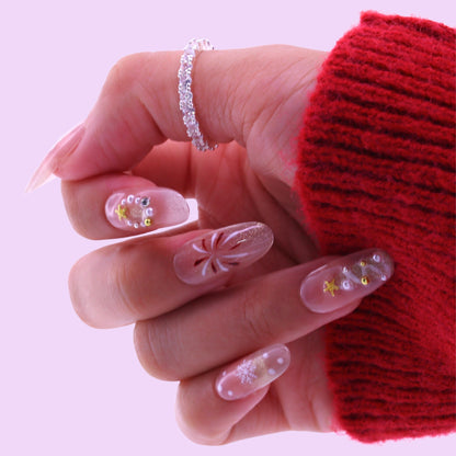 Hand with decorative nails wearing a red sleeve, Tennail handmade press on nails.