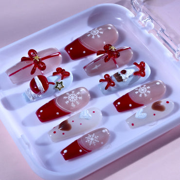 Medium Squoval Tennail press-ons with Christmas French tips, 3D bows, gifts, and snowflakes.