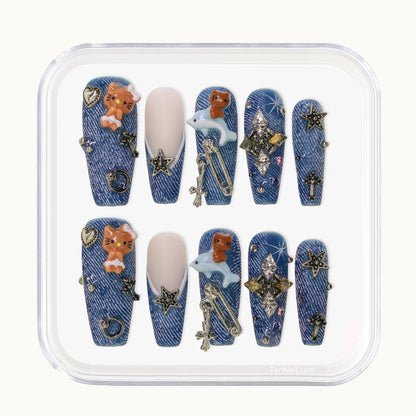 Long Coffin Tennail press-ons with denim texture, 3D kitten charms, metallic studs, and rhinestones.
