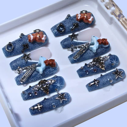 Long Coffin Tennail press-ons with denim texture, 3D kitten charms, metallic studs, and rhinestones.