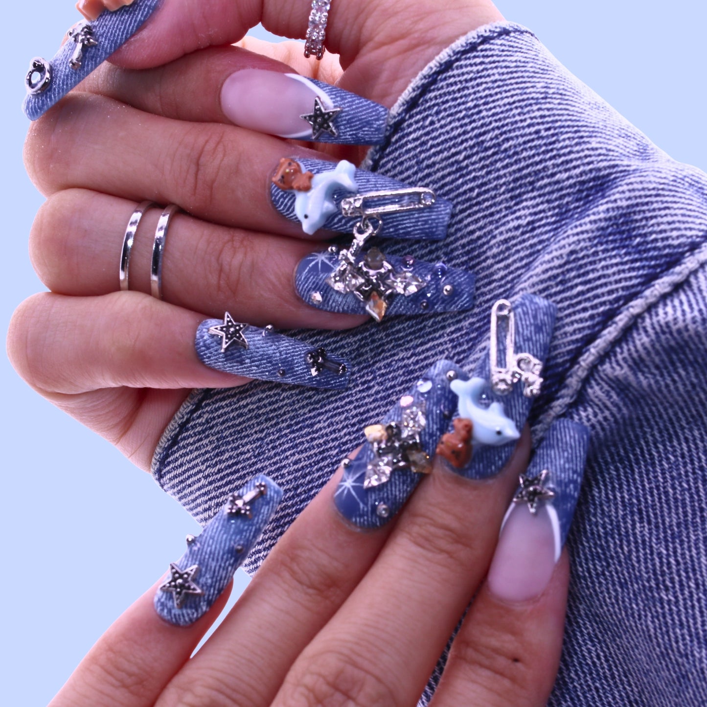 Close-up of hands with denim-themed nails and decorative elements, Tennail handmade press on nails.