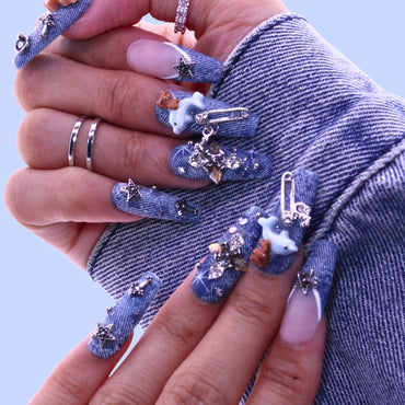 Close-up of hands with denim-themed nails and decorative elements, Tennail handmade press on nails.