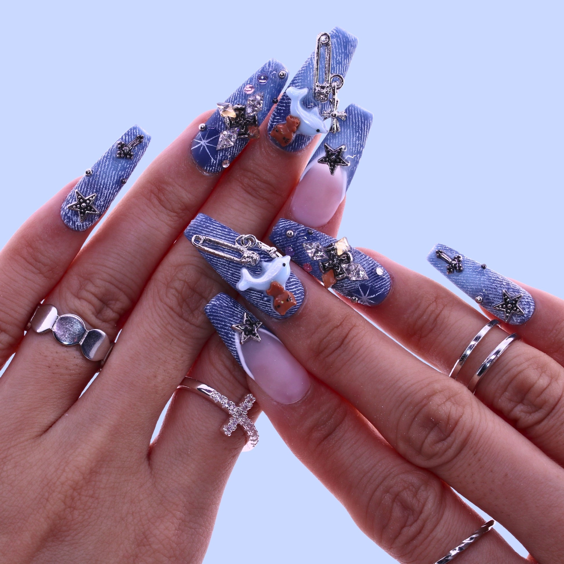 Hand with blue denim-themed nail art and silver jewelry, Tennail handmade press on nails.