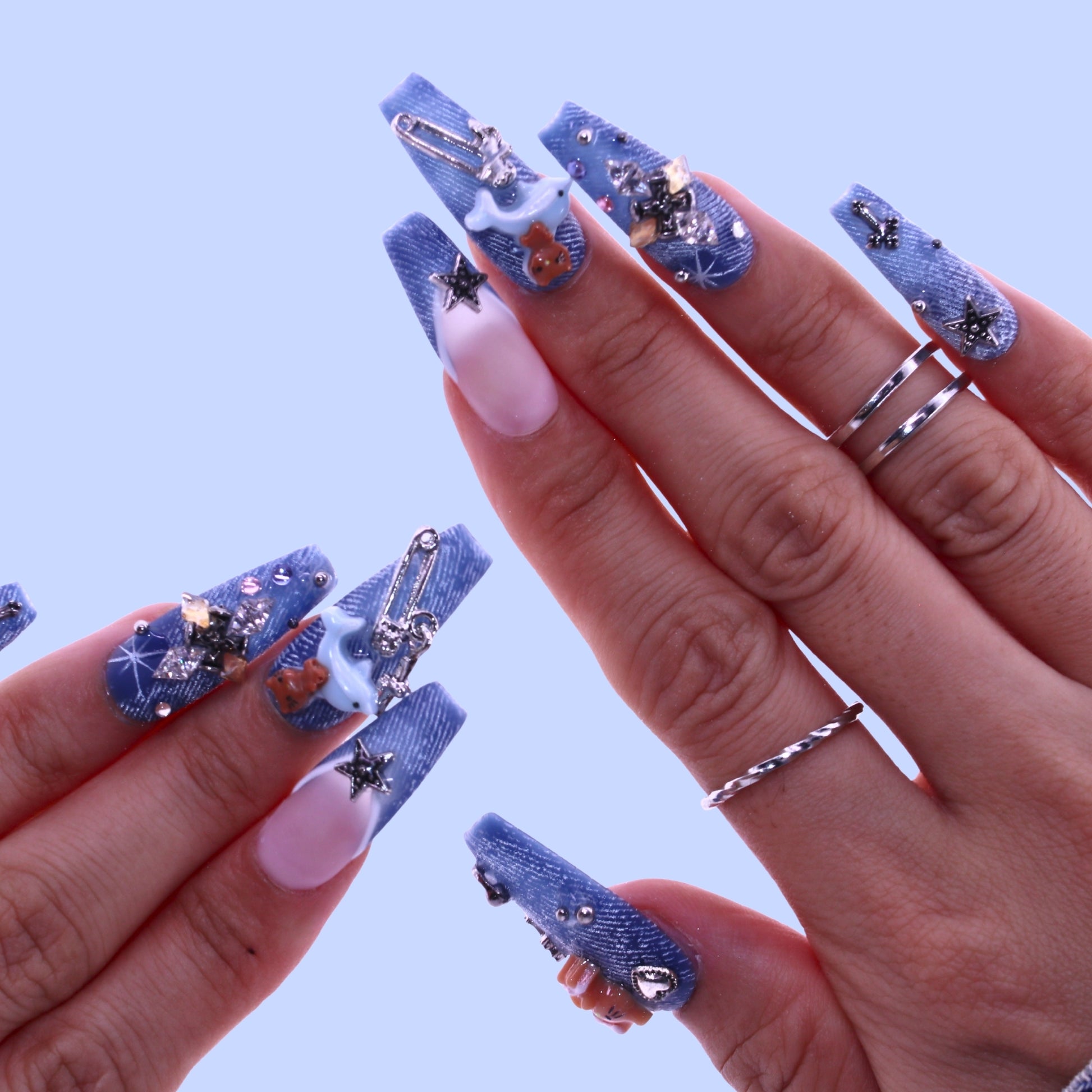 Close-up of hands with blue nail art and rhinestone decorations, Tennail handmade press on nails.