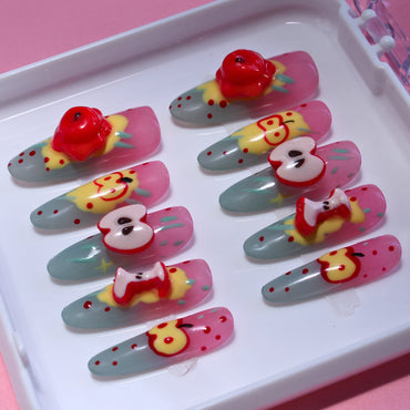 Long Oval Tennail press-ons with colorful Hand Painted cartoon splatters and 3D apple charms.