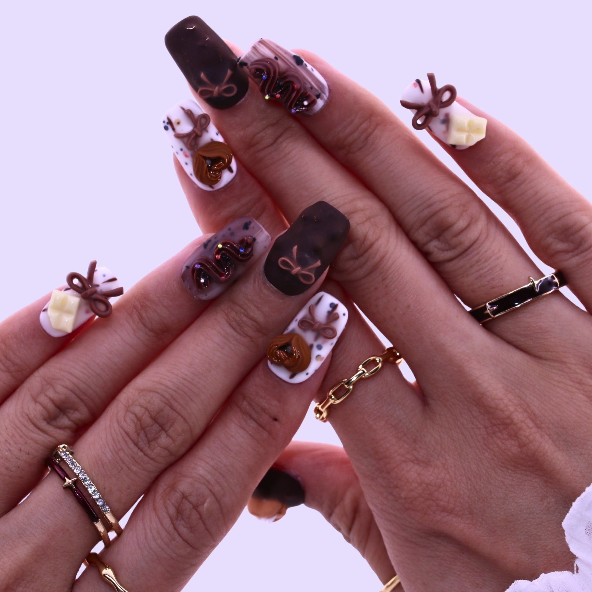 Close-up of hands with decorative nail art and multiple rings on a light , Tennail handmade press on nails.background