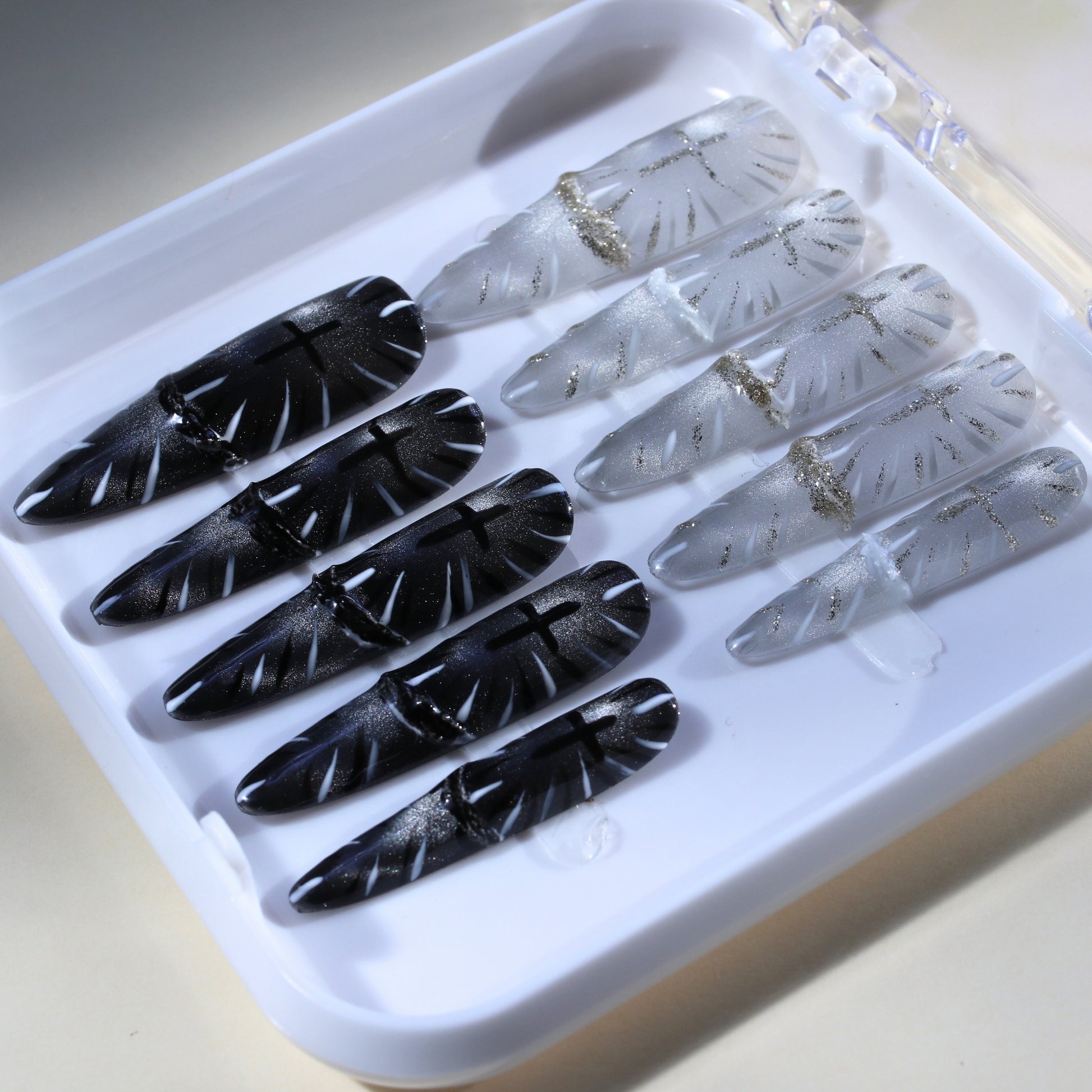 Long Stiletto Tennail press-ons in black and white Cat Eye with Gothic cross religious symbols.